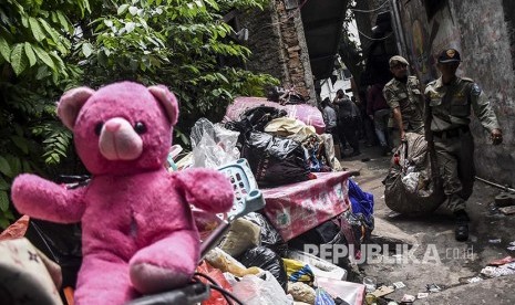 Petugas Satpol PP memindahkan  barang milik warga saat penggusuran permukiman Tamansari, Kota Bandung, Kamis (12/12). 