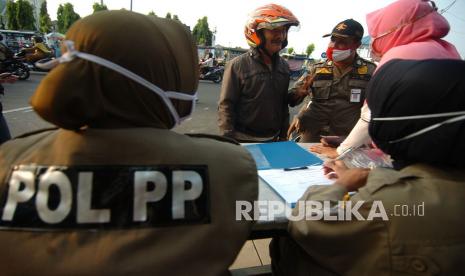 Petugas Satpol PP memberi sanksi kepada warga yang tidak mengenakan masker dengan menghafalkan Pancasila di Alun-alun Kota Tegal, Jawa Tengah, Senin (10/8/20). Warga dan pengendara bermotor yang tidak mengenakan masker mendapat sanksi menyanyikan lagu Indonesia Raya, menghafal Pancasila dan push up dalam rangka dmengakkan protokol kesehatan menyusul meningkatnya kasus Orang Tanpa Gejala (OTG) positif COVID-19 di Kota Tegal yang mencapai 66 orang.