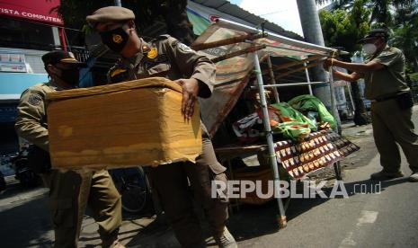 Petugas Satpol PP membongkar lapak milik pedagang saat razia pedagang kaki lima (PKL). PKL di Garut yang tak patuhi prokes selama Ramadhan akan dibubarkan. Ilustrasi.