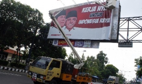 Petugas Satpol PP mencopot baliho alat peraga kampanye (APK) capres-cawapres pasangan Prabowo-Hatta di jalan A. Yani, Kota Kediri, Jawa Timur, Ahad (6/7).