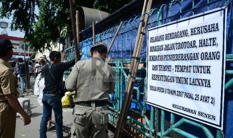 Petugas Satpol PP menertibkan pedagang di trotoar Pasar Senen, Jakarta Pusat, Rabu (21/1). ( Republika/Raisan Al Farisi)