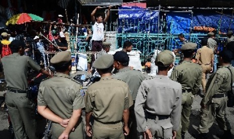 Petugas Satpol PP menertibkan pedagang di trotoar Pasar Senen, Jakarta Pusat, Rabu (21/1).