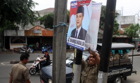  Petugas Satpol PP menertibkan spanduk caleg di sepanjang Jalan Hos Cokroaminoto, Ciledug, Tangerang, Banten, Kamis (16/1). 