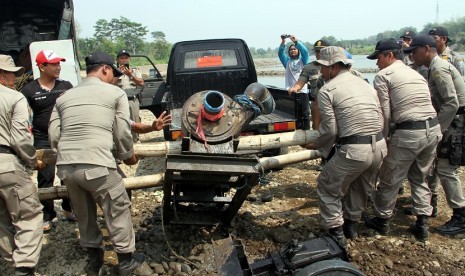 Petugas satpol PP mengangkat mesin dua mekanik penyedot pasir saat merazia penambangan pasir liar/ilegal di bantaran Sungai Brantas, Tulungagung, Jawa Timur, Kamis (22/10). 