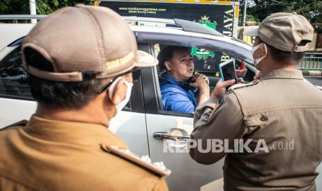 Petugas Satpol PP mengimbau kepada pengendara untuk menggunakan masker dengan baik dan benar dalam Operasi Yustisi Protokol COVID-19 di kawasan Pasar Jumat, Jakarta, Senin (14/9/2020). Operasi Yustisi tersebut dilaksanakan untuk menertibkan masyarakat agar lebih disiplin dalam menerapkan protokol kesehatan pencegahan penyebaran COVID-19. 