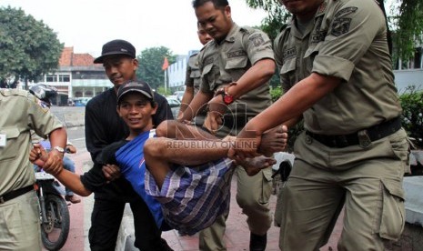  Petugas Satpol PP merazia sejumlah gelandangan di Jalan Hayam Wuruk, Jakarta, Rabu (10/7).  ( Republika/ Yasin Habibi)