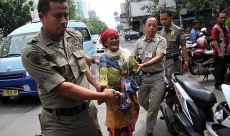  Petugas Satpol PP merazia sejumlah gelandangan di Jalan Hayam Wuruk, Jakarta, Rabu (10/7).  ( Republika/ Yasin Habibi)