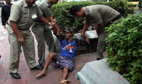  Petugas Satpol PP merazia sejumlah gelandangan di Jalan Hayam Wuruk, Jakarta, Rabu (10/7).  ( Republika/ Yasin Habibi)