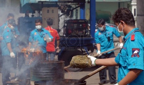   Petugas Satuan Narkoba Polres Metro Jakarta Selatan memusnahkan barang bukti narkotika jenis ganja di halaman Polres Metro Jakarta Selatan, Jumat (15/2).  (Republika/Agung Fatma Putra) 