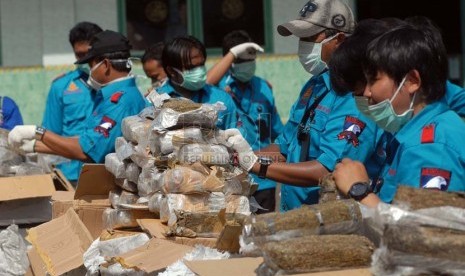   Petugas Satuan Narkoba Polres Metro Jakarta Selatan menunjukan barang bukti narkotika jenis ganja di halaman Polres Metro Jakarta Selatan, Jumat (15/2).   (Republika/Agung Fatma Putra) 