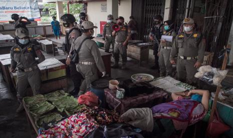 Petugas Satuan Polisi Pamong Praja (Satpol PP) dan Polisi melakukan sosialisasi penerapan Pemberlakuan Pembatasan Kegiatan Masyarakat (PPKM) - ilustrasi