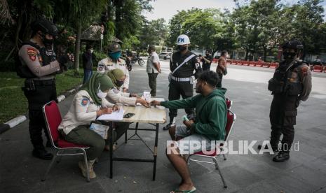 Petugas Satuan Polisi Pamong Praja (Satpol PP) memberikan sanksi teguran pengendara sepeda motor yang tidak mengenakan masker saat Operasi Yustisi di jalan Adi Sucipto, Manahan, Solo, Jawa Tengah, Rabu (22/12/2021). Operasi tersebut untuk menertibkan masyarakat agar disiplin menerapkan protokol kesehatan guna mencegah penyebaran COVID-19 jelang libur Natal dan Tahun Baru. 