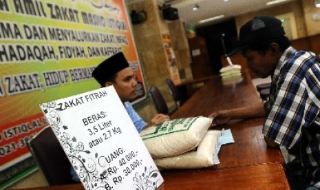 Petugas sedang berbicara dengan warga di tempat penerimaan zakat di Masjid Istiqlal, Jakarta.