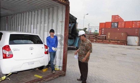 Petugas sedang melakukan simulasi keamanan pengiriman mobil via jasa pengiriman kargo kereta api, di Stasiun Barang Kampung Bandan, Jakarta, Jumat (18/7). 