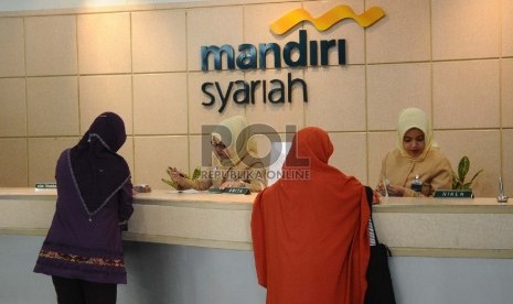  Petugas sedang melayani nasabah di kantor Bank Syariah Mandiri (BSM), Jakarta, Selasa (22/12).