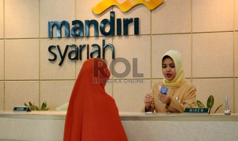 Petugas sedang melayani nasabah di kantor Bank Syariah Mandiri (BSM), Jakarta, Selasa (22/12). 