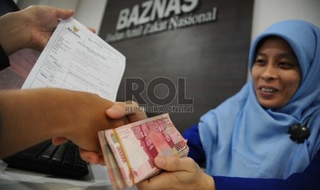 Petugas sedang melayani pembayar zakat di Baznas, Jakarta, Rabu (1/4).