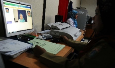 Petugas sedang memfoto dalam pembuatan e-KTP di Kelurahan Cikoko, Pancoran, Jakarta Selatan, Rabu (27/11).