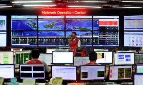 Petugas sedang mengecek jalur telekomunikasi di ruangan Network Operation Center Telkomsel,Jakarta, Selasa (7/7).