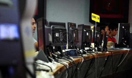 Petugas sedang mengecek jalur telekomunikasi di ruangan Network Operation Center Telkomsel,Jakarta, Selasa (7/7).