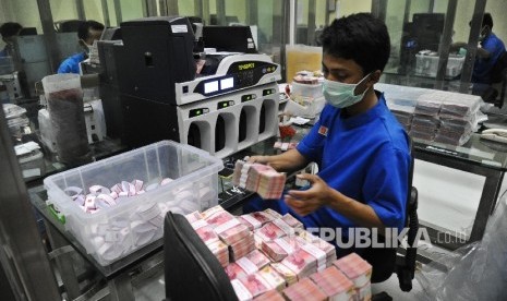  Petugas sedang menyusun tumpukan uang rupiah di Cash Center Bank BNI, Jakarta, Kamis (8\12). 