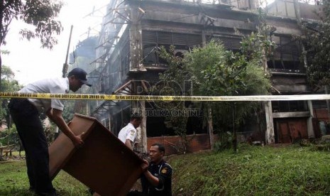  Petugas sekuriti menyelamatkan barang usai peristiwa kebakaran di Gedung C FISIP Universitas Indonesia, Depok, Jawa Barat, Selasa (7/1).   (Republika/Yasin Habibi)