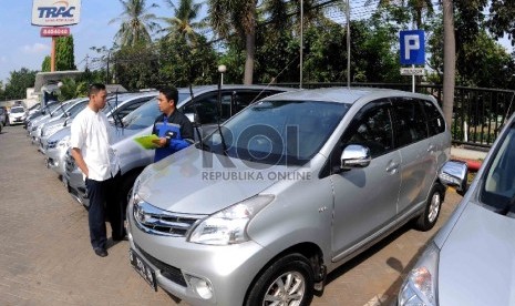 Petugas sewa mobil (kanan) memberika keterangan kepada calon penyewa terkait kondisi kendaraan sebelum digunakan di penyewaan mobil Trac (Astra Rent A Car), Jakarta, Jumat (10/7).