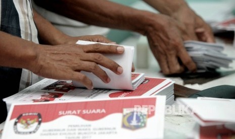 Petugas sortir dan lipat menyelesaikan pelipatan surat suara 