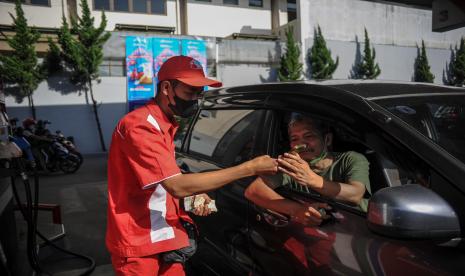 Petugas SPBU memberikan panduan kepada seorang pengendara untuk pengisian BBM melalui aplikasi MyPertamina di Bandung, Jawa Barat.