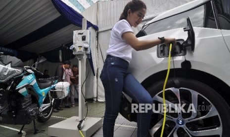 Petugas stan melakukan pengisian kendaraan mobil berbahan bakar listrik disalah satu stan saat acara LIKE (Learning, Innovation, Knowledge & Exhibition) di Kantor Pusat PLN, Jakarta, Selasa (17/10).