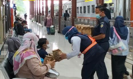 Petugas Stasiun Purwokerto membagi-bagikan takjil pada penumpang. 