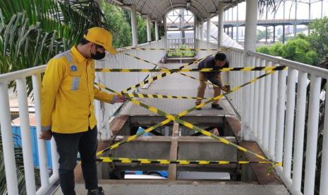 Petugas Sudin Bina Marga Jakarta Barat memasang garis pengaman pada JPO Warung Gantung di Semanan, Kalideres, Jakarta Barat, Senin (7/8/2023). 