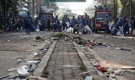 Petugas Sudin Sumber Daya Air membersihkan jalan pascakerusuhan di kawasan Kantor Bawaslu, Jakarta, Kamis (23/5).