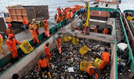 Petugas Suku Dinas Kebersihan Kepulauan Seribu memindahkan sampah dari kapal pengangkut sampah ke truk di Pelabuhan Muara Angke, Jakarta Utara, Rabu (16/12). (Republika/Agung Supriyanto)