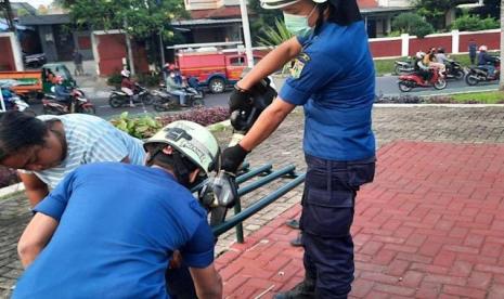 Petugas Suku Dinas Penanggulangan Kebakaran dan Penyelamatan Jakarta Timur (Sudin Gulkarmat Jaktim) mengevakuasi orang dengan gangguan jiwa (ODGJ) perempuan yang kakinya terjepit di bangku taman di Jalan Jati, Kecamatan Pasar Rebo, Jaktim, Kamis (31/3/2022). 