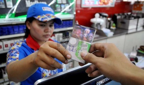 Petugas supermarket menunjukan sejumlah rokok yang sudah dilengkapi peringatan bergambar akan bahaya merokok di Jakarta, Senin (23/6).