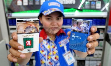 Petugas supermarket menunjukan sejumlah rokok yang sudah dilengkapi peringatan bergambar akan bahaya merokok di Jakarta, Senin (23/6).