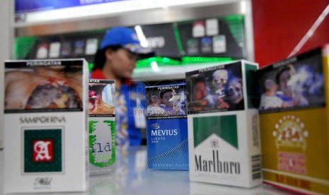 Petugas supermarket menunjukan sejumlah rokok yang sudah dilengkapi peringatan bergambar akan bahaya merokok di Jakarta, Senin (23/6).