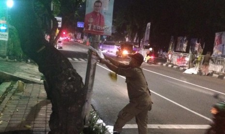 Petugas Tamtib DKI membersihkan atribut kampanye di kawasan Pancoran, Jakarta Selatan, Ahad dinihari, (14/1).