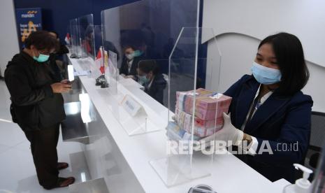 Petugas teller menata pecahan rupiah di Bank Mandiri Cabang Jakarta Sudirman, Jakarta, Senin (23/8/2021). Himpunan Bank-Bank Milik Negara (HIMBARA) optimistis dalam penyaluran kredit di sisa tahun 2021 terkait pemulihan ekonomi nasional, sementara itu Bank Mandiri telah menyalurkan Kredit Usaha Rakyat (KUR) sebesar Rp22,5 triliun hingga Juli 2021 untuk mendukung kegiatan masyarakat di tengah pandemi COVID-19. 