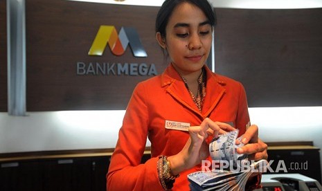 Petugas teller menghitung uang di kantor pusat Bank Mega, Jakarta. ilustrasi