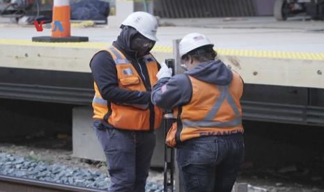 Petugas tengah melakukan pengecekan rel kereta.