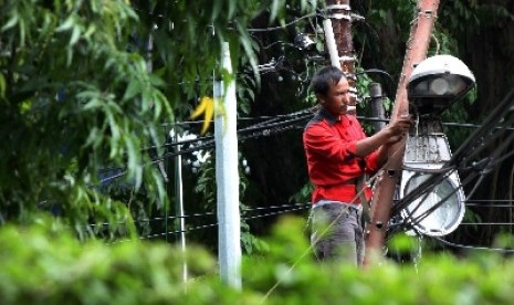 Petugas tengah memasang lampu penerangan jalan umum (PJU). 