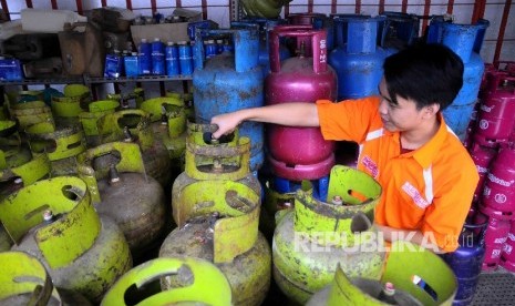  Petugas tengah memeriksa gas elpiji tiga kilogram (kg) di agen penjualan tabung gas SPBU Pertamina Cikini, Jakarta, Kamis (15/12). 