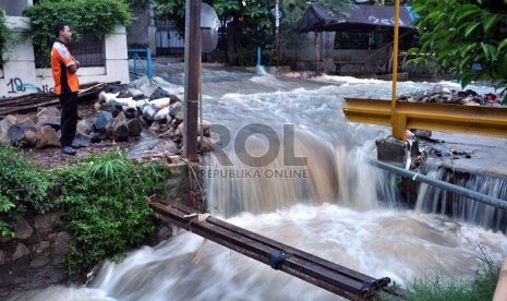  Petugas tengah memperhatikan arus air akibat jebolnya tanggul Kali Laya di perumahan Bukit Cengkeh II, Depok, Jawa Barat, Selasa (13/11). (Rakhmawaty La'lang)