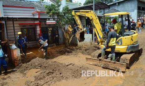 Petugas terkait, aparat dan relawan bersama warga membersihkan material sisa banjir bandang yang melanda Komplek Jati Endah Regency, Pasirjati, Cilengkrang, Kabupaten Bandung, Senin (11/2).