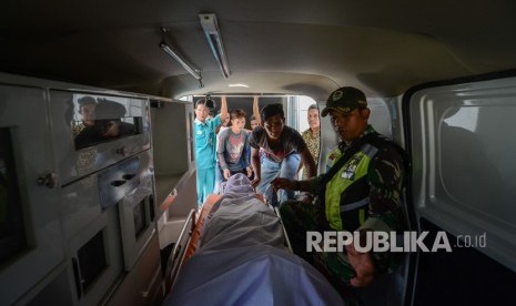 Petugas TNI membawa jenazah korban minuman keras (miras) oplosan ke dalam ambulans di Rumah Sakit Umum Daerah (RSUD) Cicalengka, Kabupaten Bandung, Jawa Barat, Jumat (13/4). 