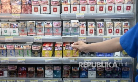   Petugas toko mengambil rokok untuk konsumen di salah satu ritel, Jakarta, Ahad (21/8). (Republika/  Wihdan)