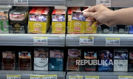 Petugas toko mengambil rokok untuk konsumen di salah satu ritel, Jakarta, Ahad (21/8). (Republika/ Wihdan)