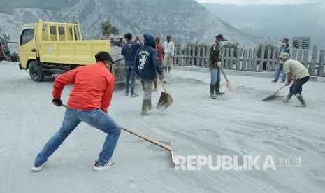 Petugas TWA Tangkuban Parahu berusaha mengangkat debu tebal yang memenuhi parkiran di sekitar kawah, Sabtu (27/7), setelah sebelumnya mengalami erupsi kecil, Jumat(26/7).